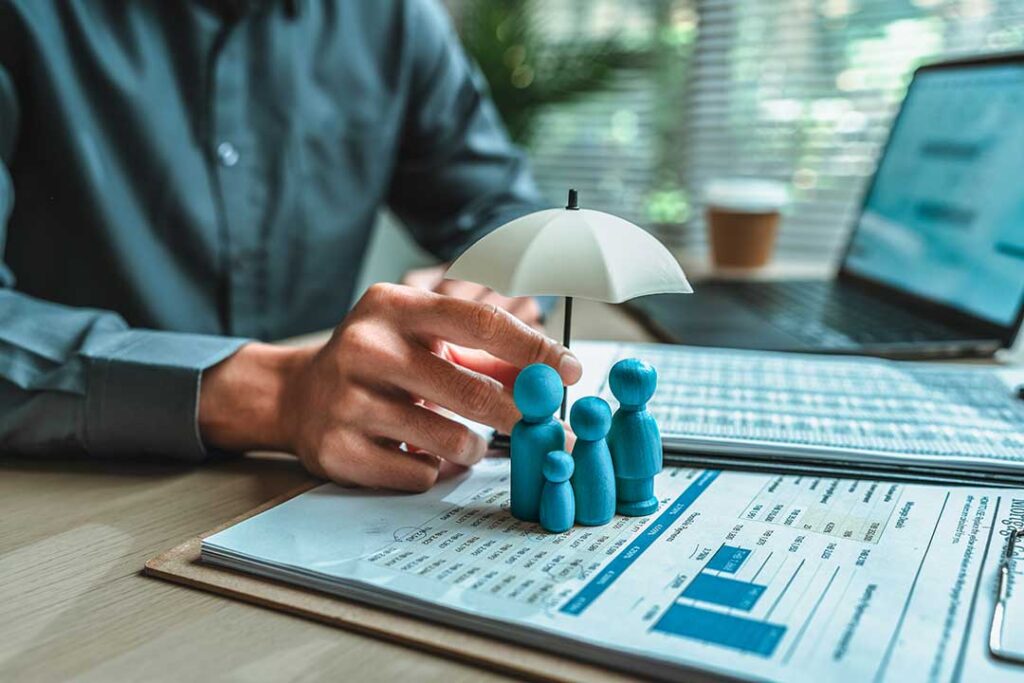 A family reviews life insurance documents and financial papers together at a kitchen table.